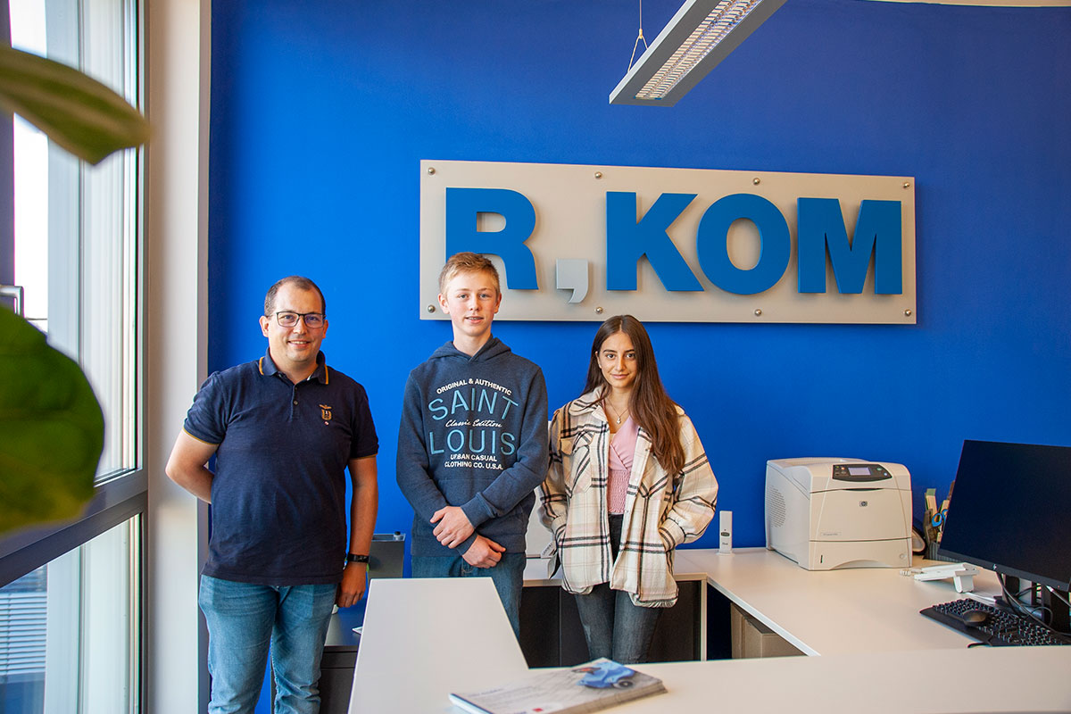 Daniel Böhm, R-KOM Ausbildungsleiter, begrüßt die zwei neuen Auszubildenden