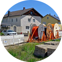 Glasfaser-Baustelle in Holzheim; im Vordergrund Glasfaser-Kabeltrommeln und im Hintergrund Wohnhäuser